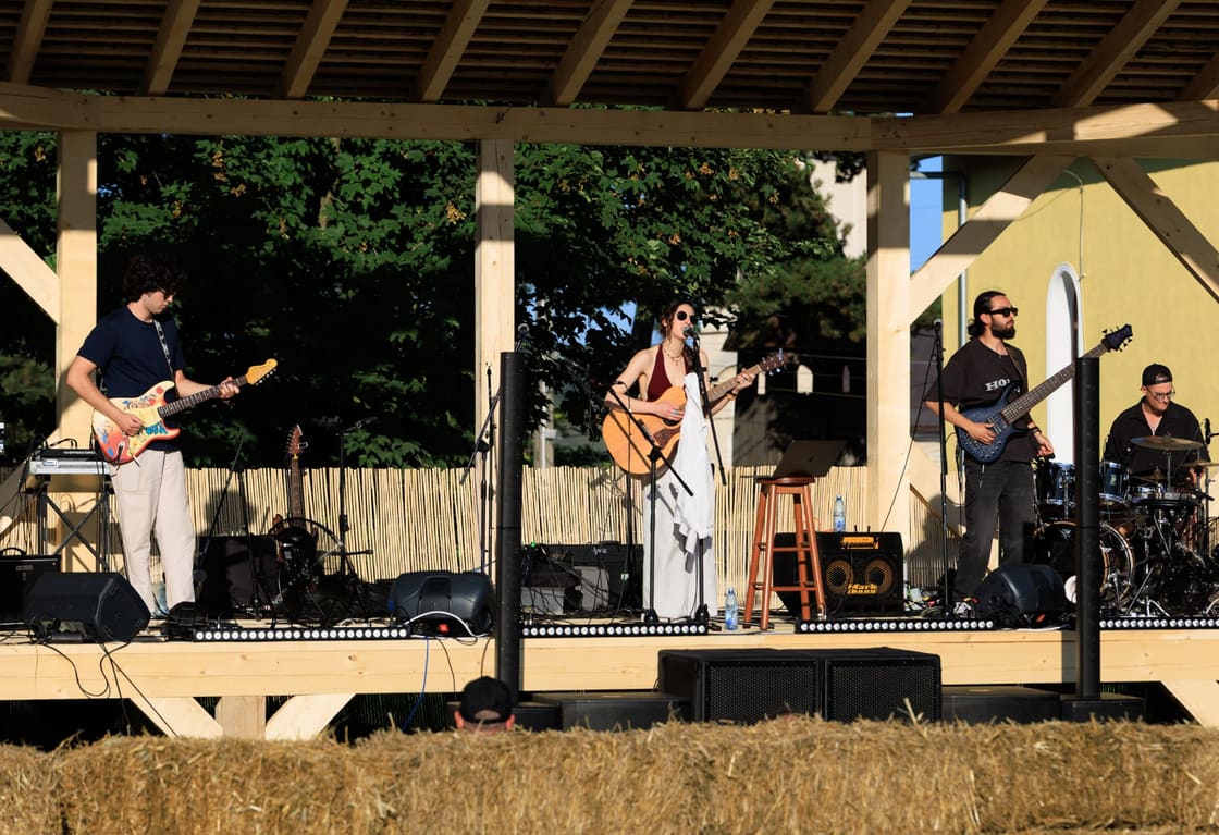 The band on an open-air stage seen from the field